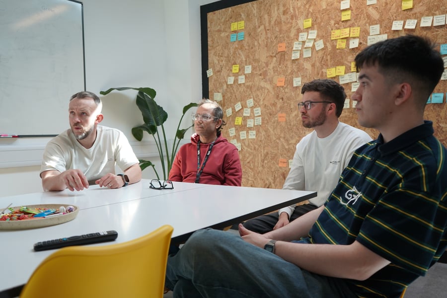 Team sat round a table, having a discussion.